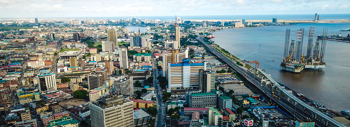 An aerial view of a busy city district in Lagos, Nigeria bordering the Lagos lagoon to the right