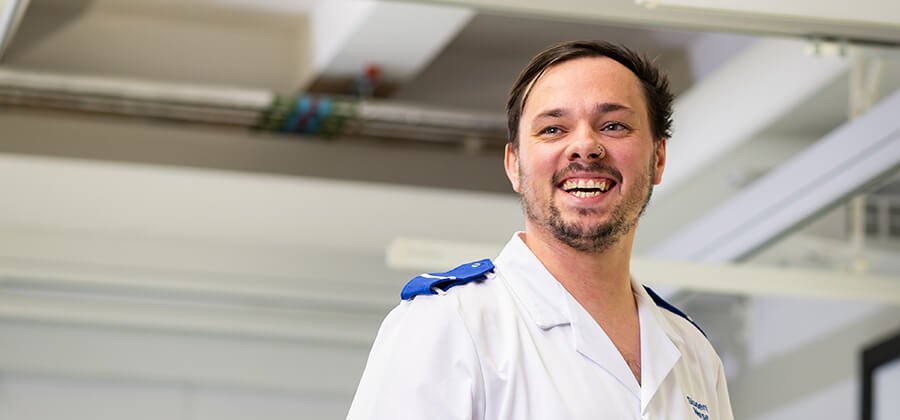 Adult nursing student in scrubs smiling