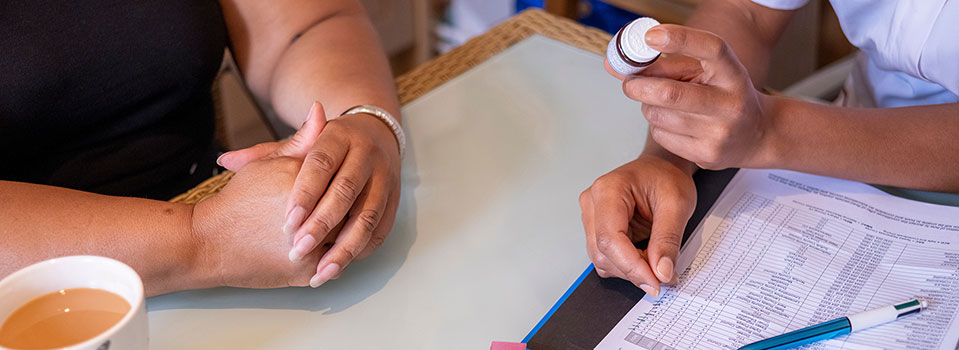 Close up on hands as a nurse shows pills to a patient