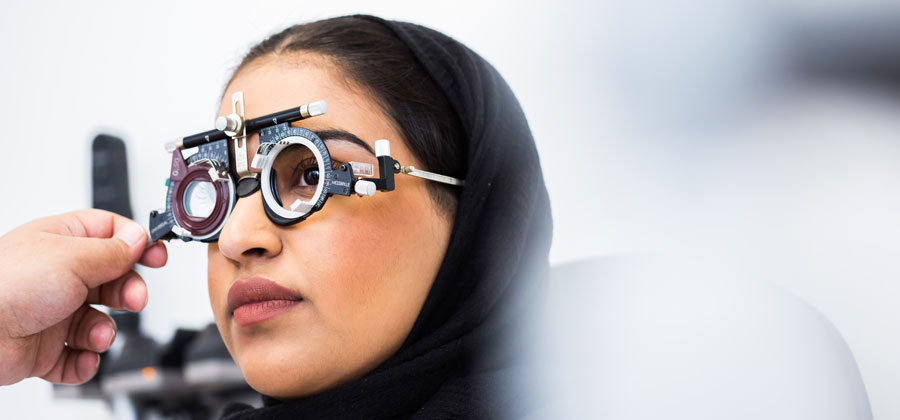 An optometry student wearing eye test equipment.