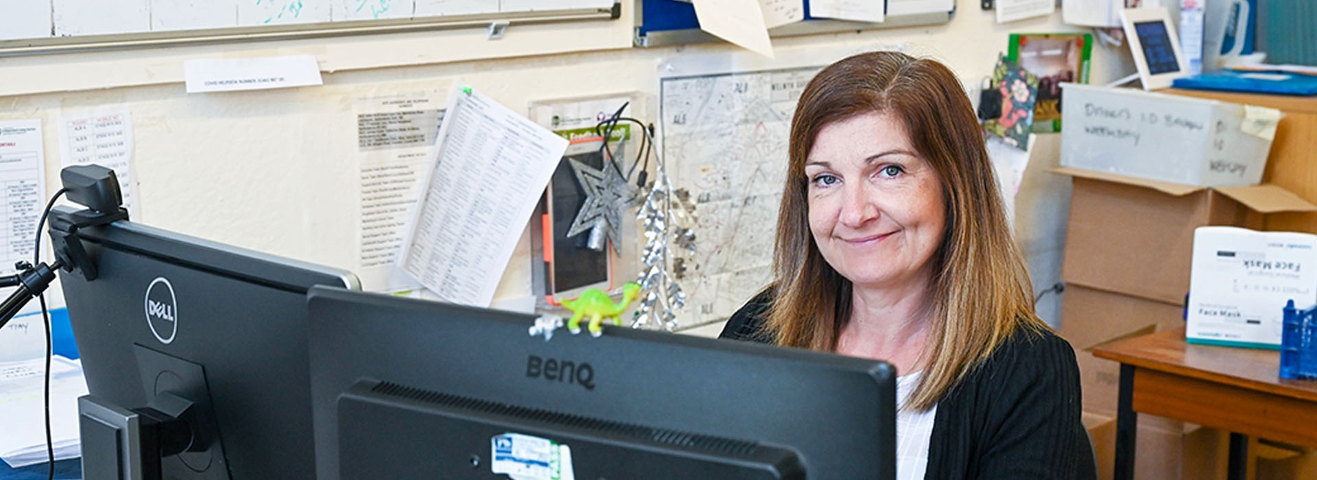 A woman is sat working at her desktop computer.
